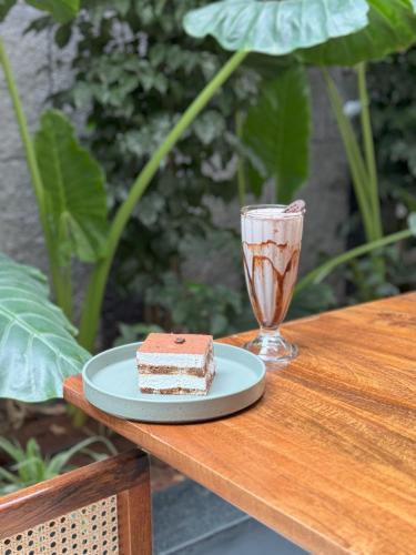a piece of cake on a plate next to a glass at SKYLA Studios & Suites - Kondapur in Hyderabad