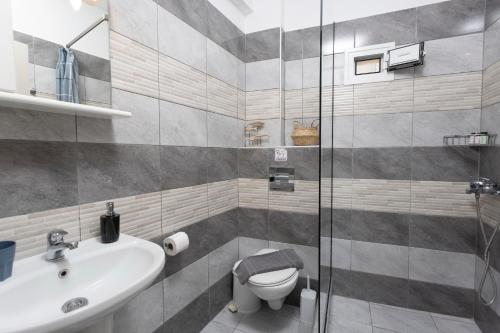ein Bad mit einem Waschbecken, einem WC und einer Dusche in der Unterkunft Anastasia Studios Hanioti in Chaniotis
