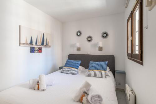 Résidence La Palme d'Azur - Cannes في كان: غرفة نوم مع سرير أبيض كبير مع وسائد زرقاء