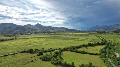 an aerial view of a field with mountains in the background at Gazdinstvo Vukanović - Kuća za odmor in Trebinje