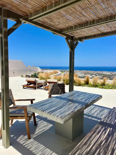 a picnic table and chairs on a patio with the beach at Lavadoze Luxury Suites in Éxo Goniá