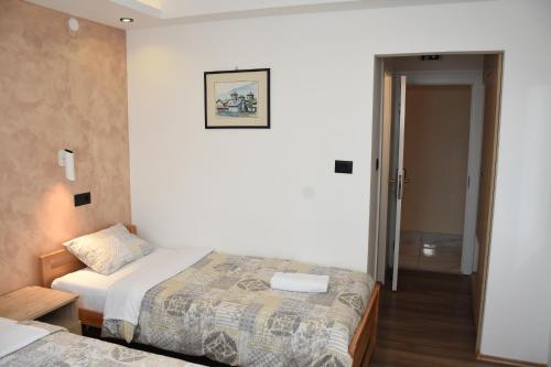 a hotel room with two beds and a hallway at Hotel "Srbija Tis" in Zaječar