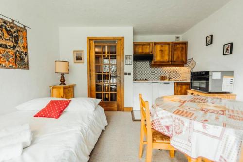 - une cuisine avec 2 lits et une table dans une chambre dans l'établissement Studio au pied des pistes et golf Megeve, à Megève