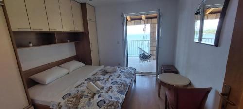 a bedroom with a bed and a table and a window at Adriatic - Apartment with jacuzzi in Sobra