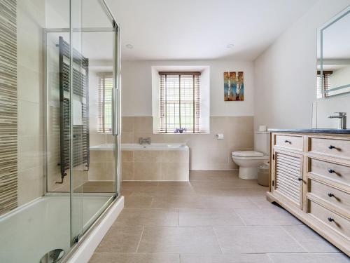 uma casa de banho com um chuveiro, uma banheira e um WC. em The Oaks em Windermere