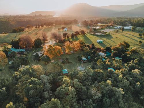 an aerial view of a farm with tents and trees at Firefly Falls in Plettenberg Bay