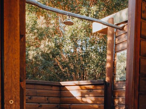an open door with a view of a tree at Firefly Falls in Plettenberg Bay