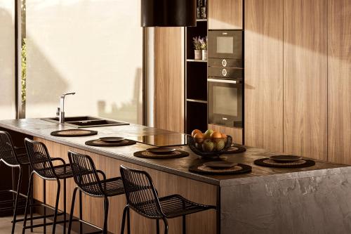 a kitchen with a counter with a bowl of fruit on it at Villa Fuerte Chania - Including Two 7-seater Vans, Airport Shuttle in Alikianós