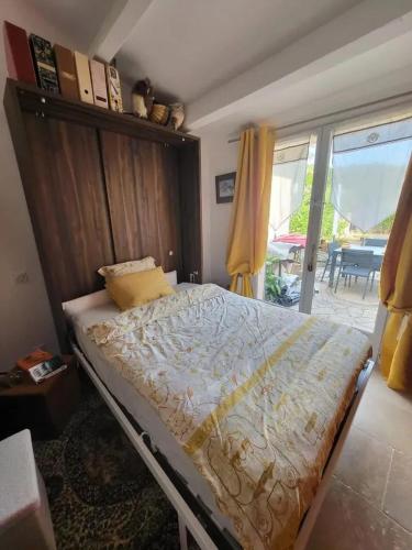 une chambre avec un lit et une grande fenêtre dans l'établissement Maison charmante à Roquebrune-sur-Argens avec piscine partagée, à Roquebrune-sur Argens