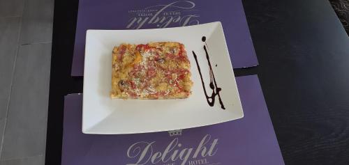 Delight Corfu Apart Hotel, Sidari في سيداري: قطعة من الطعام على طبق على طاولة