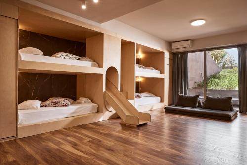 a room with two bunk beds and a window at Villa Fuerte Chania - Including Two 7-seater Vans, Airport Shuttle in Alikianós