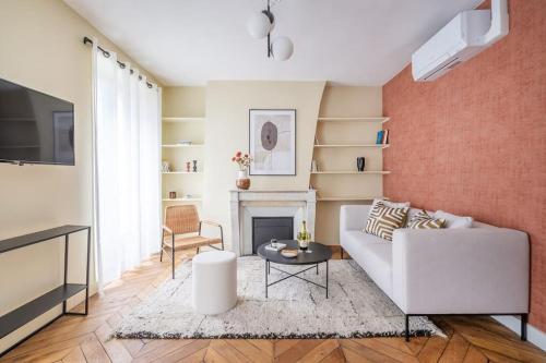 un salon avec un canapé blanc et une cheminée dans l'établissement 3#Two Bedrooms#Champs Elysées#Arc de Triomphe#AC, à Paris