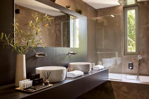 a bathroom with two sinks and a large mirror at Villa Fuerte Chania - Including Two 7-seater Vans, Airport Shuttle in Alikianós