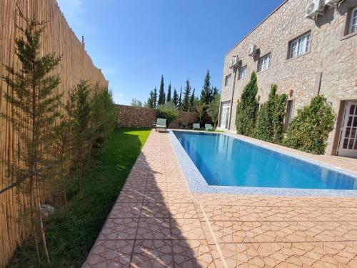 a swimming pool in a yard next to a building at Sakia Talamanzou in Talamennzou