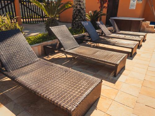 a row of wicker chairs sitting on a patio at Pousada Acqua Bella PISCINA CLIMATIZADA in Bertioga