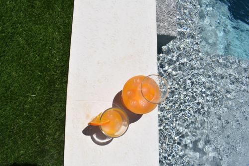 a glass of orange juice next to a swimming pool at Casa da Espiga - Alentejo in Trigaches