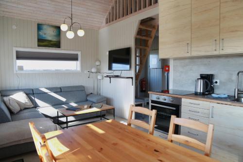 a kitchen and living room with a table and a couch at Eldhraun Holiday Home in Kirkjubæjarklaustur