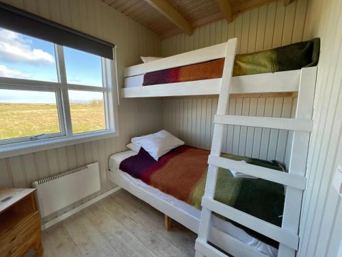 a bedroom with two bunk beds and a window at Eldhraun Holiday Home in Kirkjubæjarklaustur