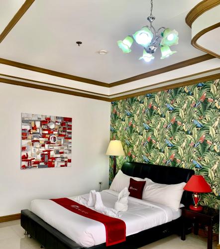 a bedroom with a bed with a painting on the wall at Holiday Plaza Hotel Tuguegarao City in Tuguegarao City