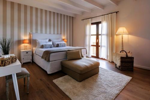 a bedroom with a large bed and a chair at La Farm Baleares in Santa Maria del Camí