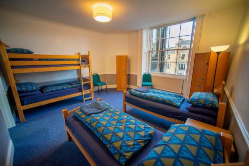 a room with three bunk beds and a window at Glasgow Youth Hostel in Glasgow