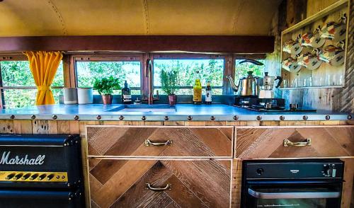 a kitchen with a stove and a counter top at American School Bus Glamping with Hot Tub in Woolacombe! in Lee