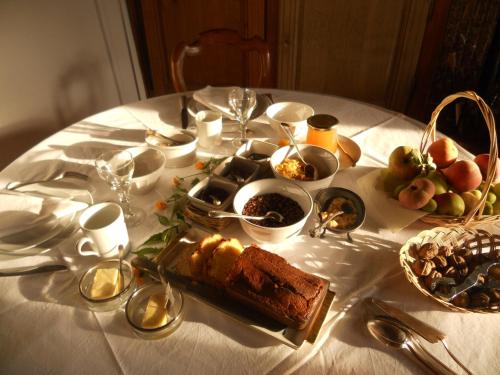 una mesa blanca con un plato de comida. en Ferme De Guersignies B&B, en Bas-Lieu