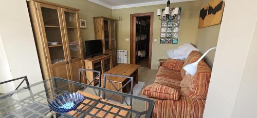 - un salon avec un canapé et une table dans l'établissement Apartamento Sierra Nevada, à Sierra Nevada