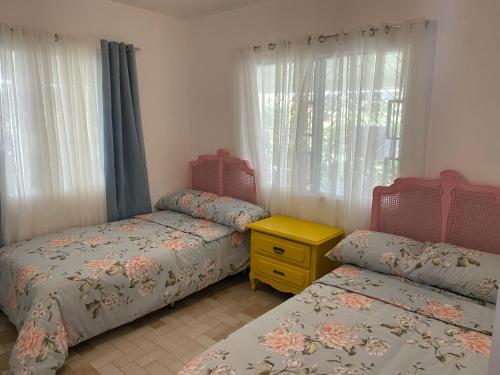a bedroom with two twin beds and a window at Vacation Garden Home with kiddie pool, central aircon, Netflix, billiards, table tennis and karaoke in Cavite