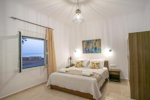 a bedroom with a large bed and a window at Baloma Apartment in Falasarna