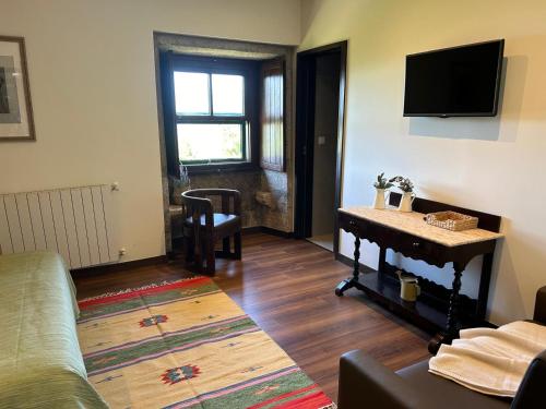 a living room with a couch and a table and a television at Convento San Payo in Vila Nova de Cerveira
