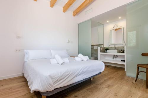 una camera da letto con un grande letto bianco e uno specchio di Agroturismo Cal Tio 4, YourHouse a Costitx