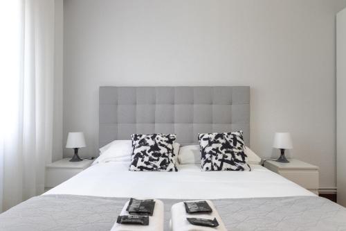 een slaapkamer met een groot wit bed met 2 kussens bij Etxebarria apartment by People Rentals in Bilbao