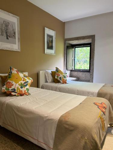 a bedroom with two beds and a window at Convento San Payo in Vila Nova de Cerveira