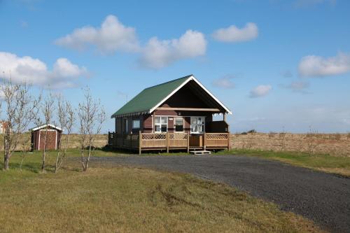 a house with a green roof on the side of a road at Eldhraun Holiday Home in Kirkjubæjarklaustur