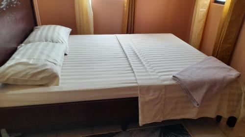 - un lit avec des draps et des oreillers blancs dans l'établissement Angie's Cove, modern get-away overlooking Castries, à Castries