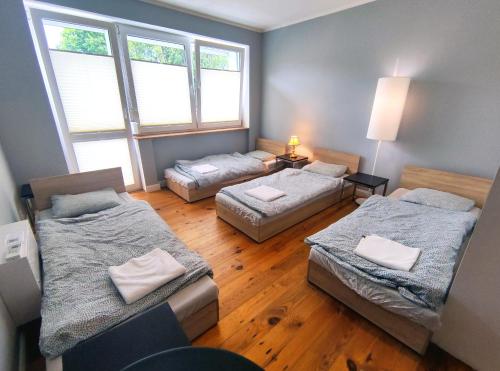 a room with three beds in a room at Apartament Nowogard Centrum - Self Check in - Wejście na KOD in Nowogard