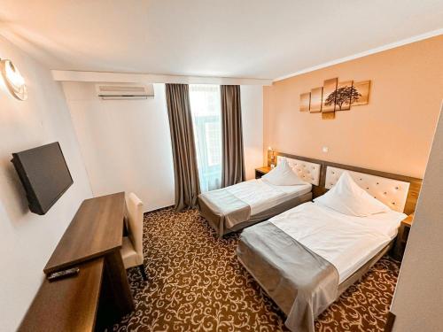 a hotel room with two beds and a desk at Hotel Neon in Timişoara