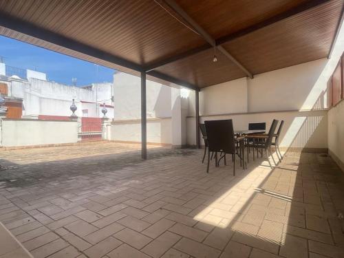 a patio with a table and chairs on a roof at Ático con terraza privada cerca de la catedral in Seville
