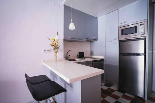 a kitchen with a white counter and a black refrigerator at Ático con terraza privada cerca de la catedral in Seville