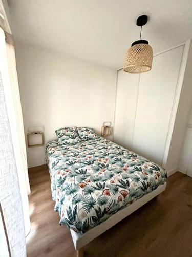 une chambre avec un lit avec une couette fleurie dans l'établissement Resplendissant YourHostHelper, à Bayonne