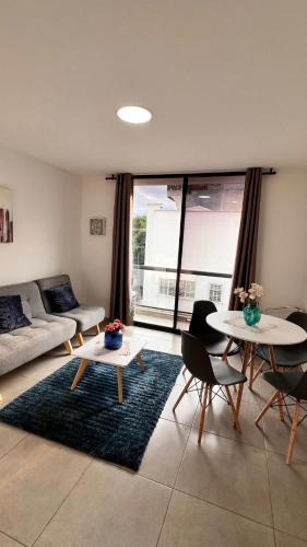 a living room with a couch and a table and chairs at PARK 2009 Apartaestudios in Cali