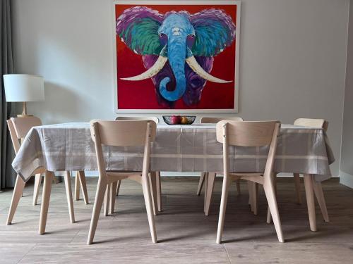 une table à manger avec une peinture d'éléphant dans l'établissement Modern 3 bedroom apartment close to lifts, à Morzine