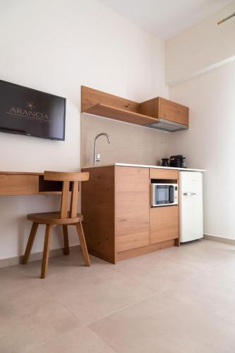 a kitchen with a counter and a sink and a chair at Arancia Elegant Rooms and Suites in Tolo
