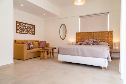 a bedroom with a bed and a couch at Arancia Elegant Rooms and Suites in Tolo