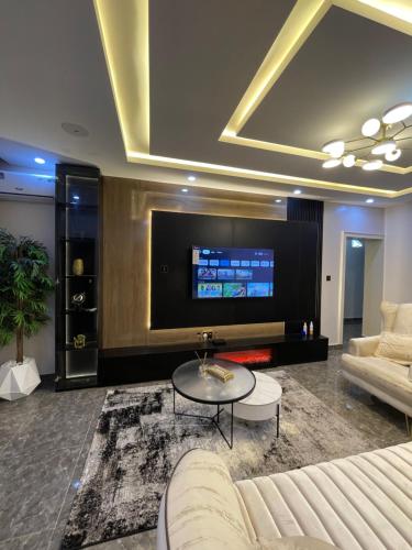KadobunkuroにあるBlissful Oasis Apartmentのテレビ、ソファ、テーブルのあるリビングルーム