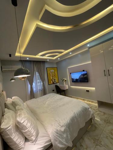 KadobunkuroにあるBlissful Oasis Apartmentのベッドルーム(白いベッド1台、天井テレビ付)