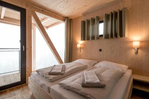 a bedroom with a bed with two pillows on it at Alpenchalets Reiteralm by ALPS RESORTS in Schladming