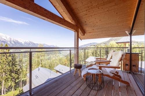 a wooden deck with a bench and a table and chairs at Alpenchalets Reiteralm by ALPS RESORTS in Schladming