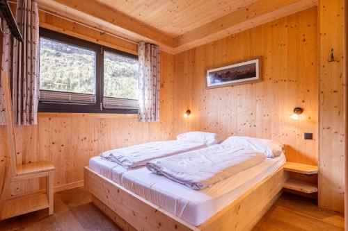 a bedroom with a bed in a wooden room at Alpenchalets Reiteralm by ALPS RESORTS in Schladming
